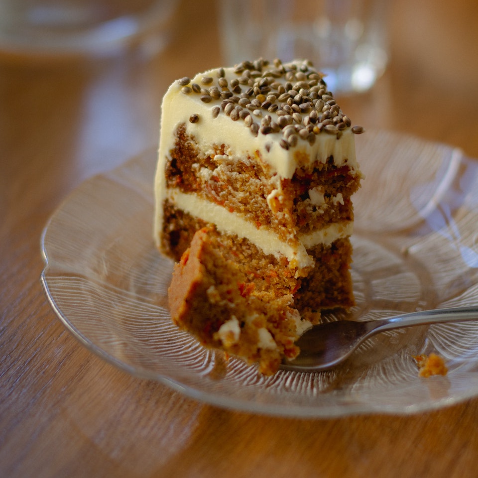 Slice of carrot cake on a plate with a fork